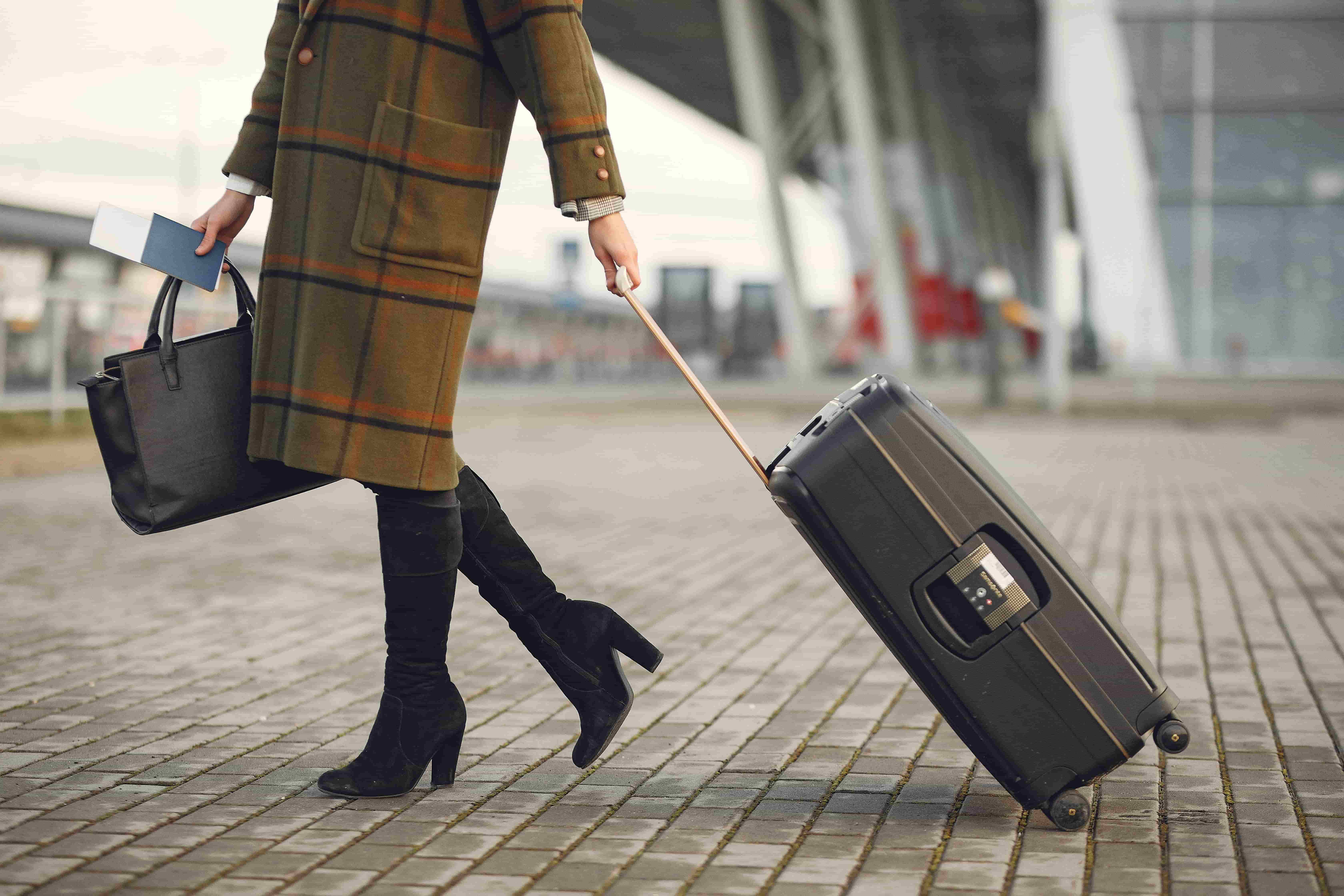 woman arriving at airport with her luggage in her home country after assignment abroad